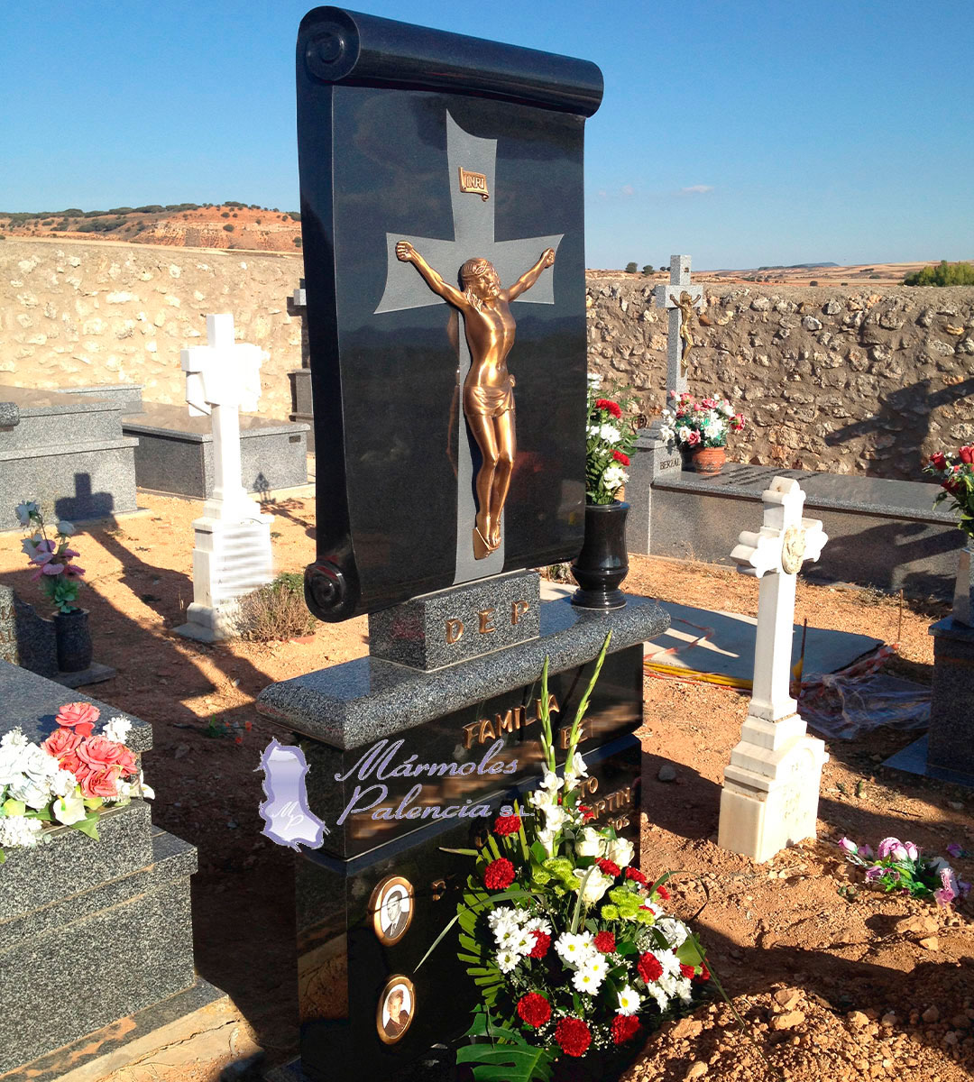 Cruz realizada en granito negro intenso y Quintana con forma de pergamino y cristo. Mármoles Palencia