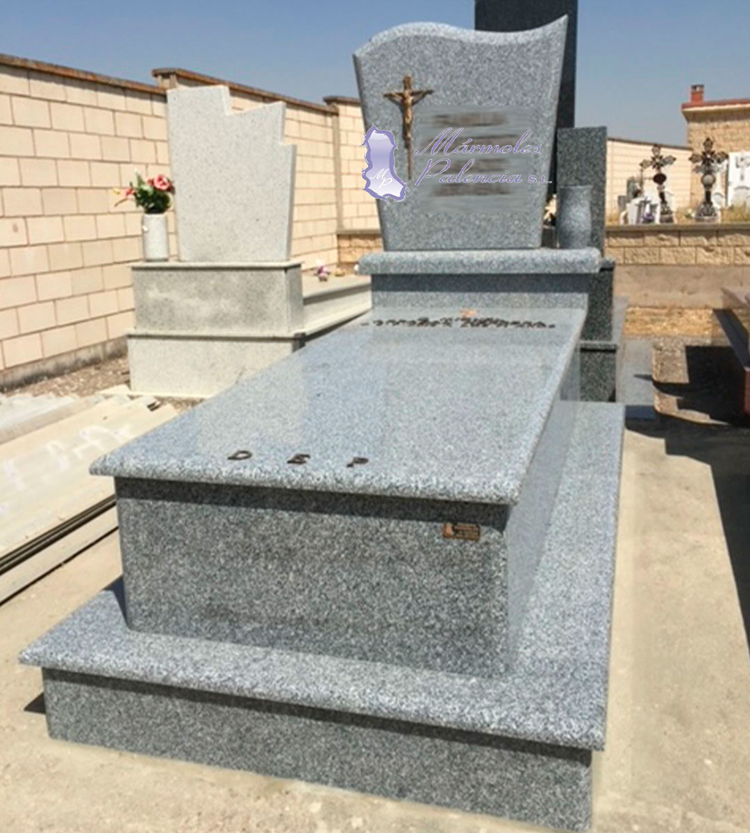 Panteón en granito Quintana de 2 alturas con cruz con Cristo y letras de bronce con jarrón. Mármoles Palencia